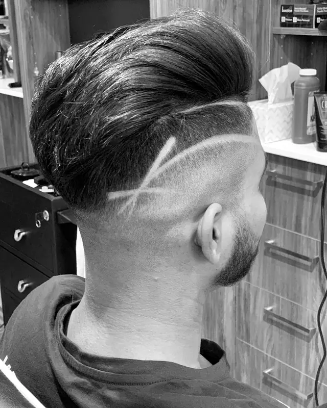 Back of a skin fade with a slicked top and a shaved line design